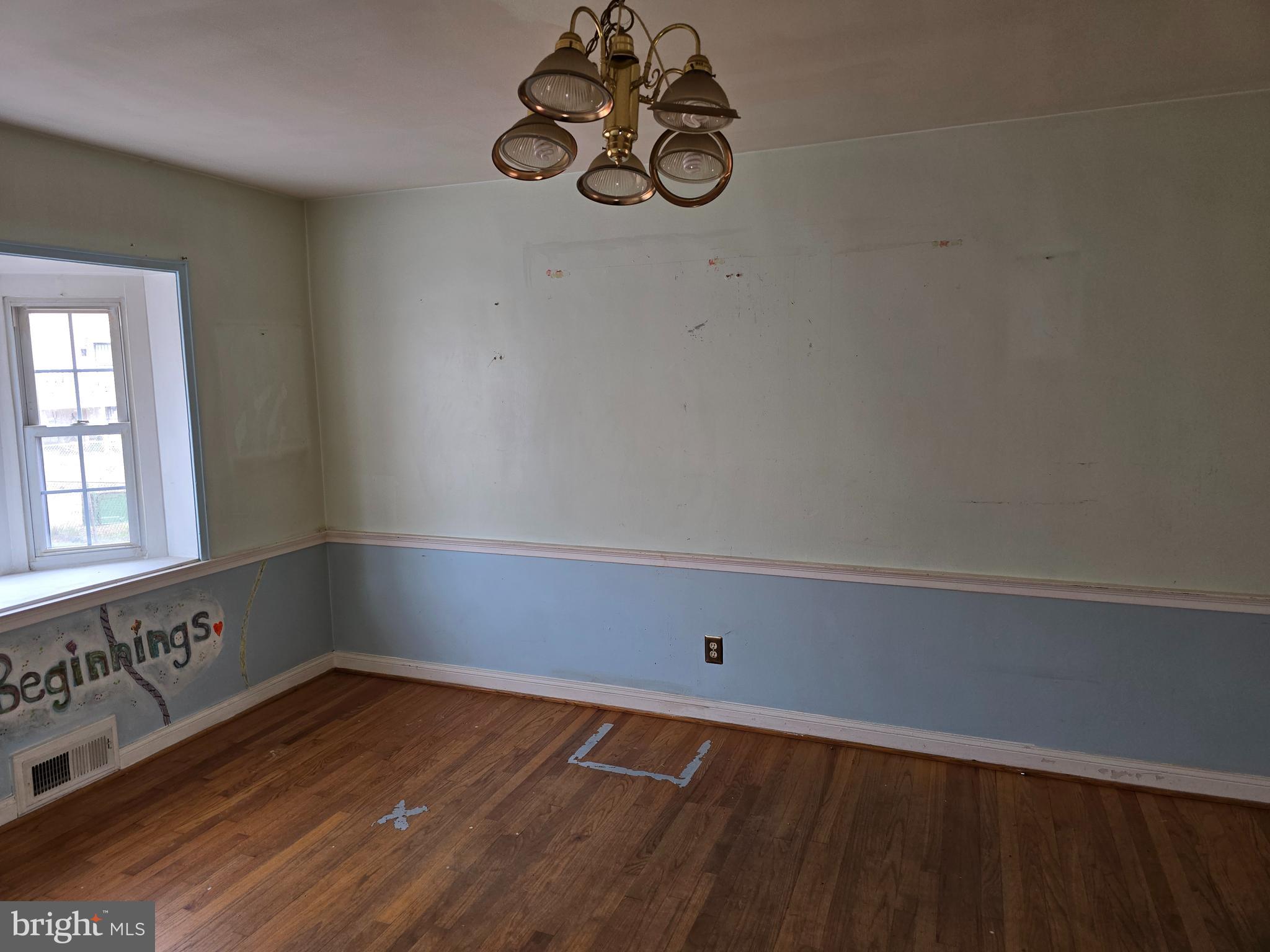 1708 Hartsdale Road Baltimore, MD 21239 - Photo 8 of 26 a view of an empty room with wooden floor and windows