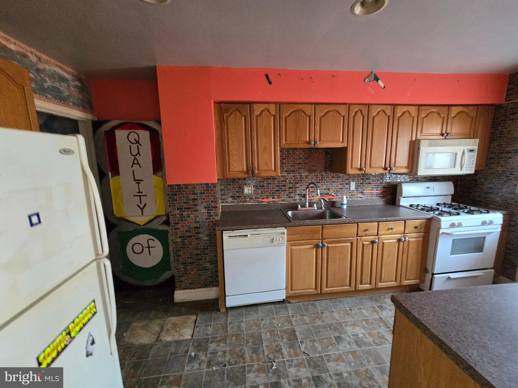 1708 Hartsdale Road Baltimore, MD 21239 - Photo 9 of 26 a kitchen with a refrigerator a stove top oven a sink and dishwasher
