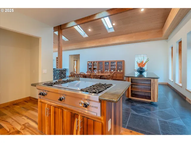 a kitchen with stainless steel appliances granite countertop a stove and a view of living room