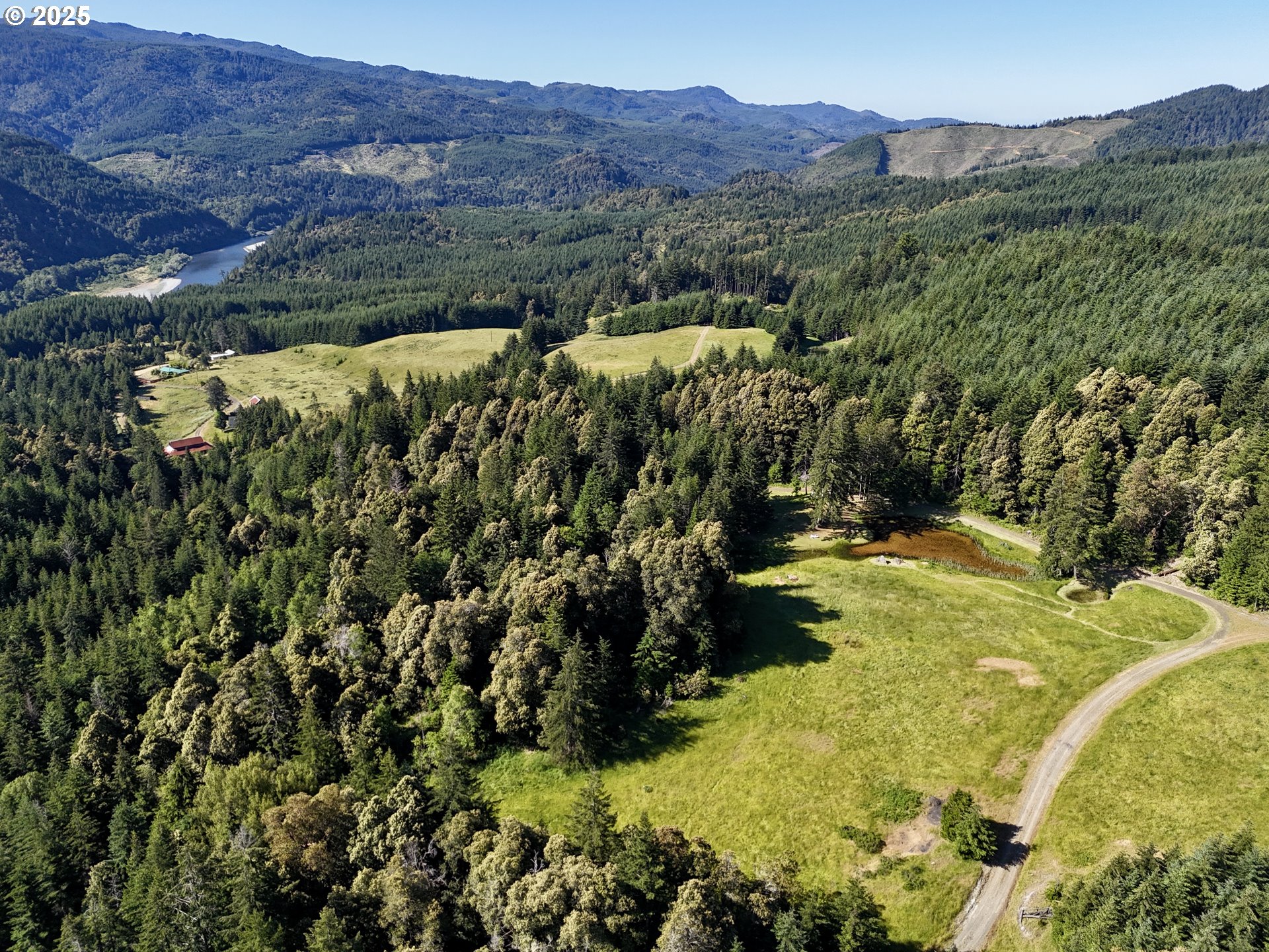 32855 Miller Ranch Road Gold Beach, OR 97444 - Photo 2 of 47 a view of a lush green hillside and houses
