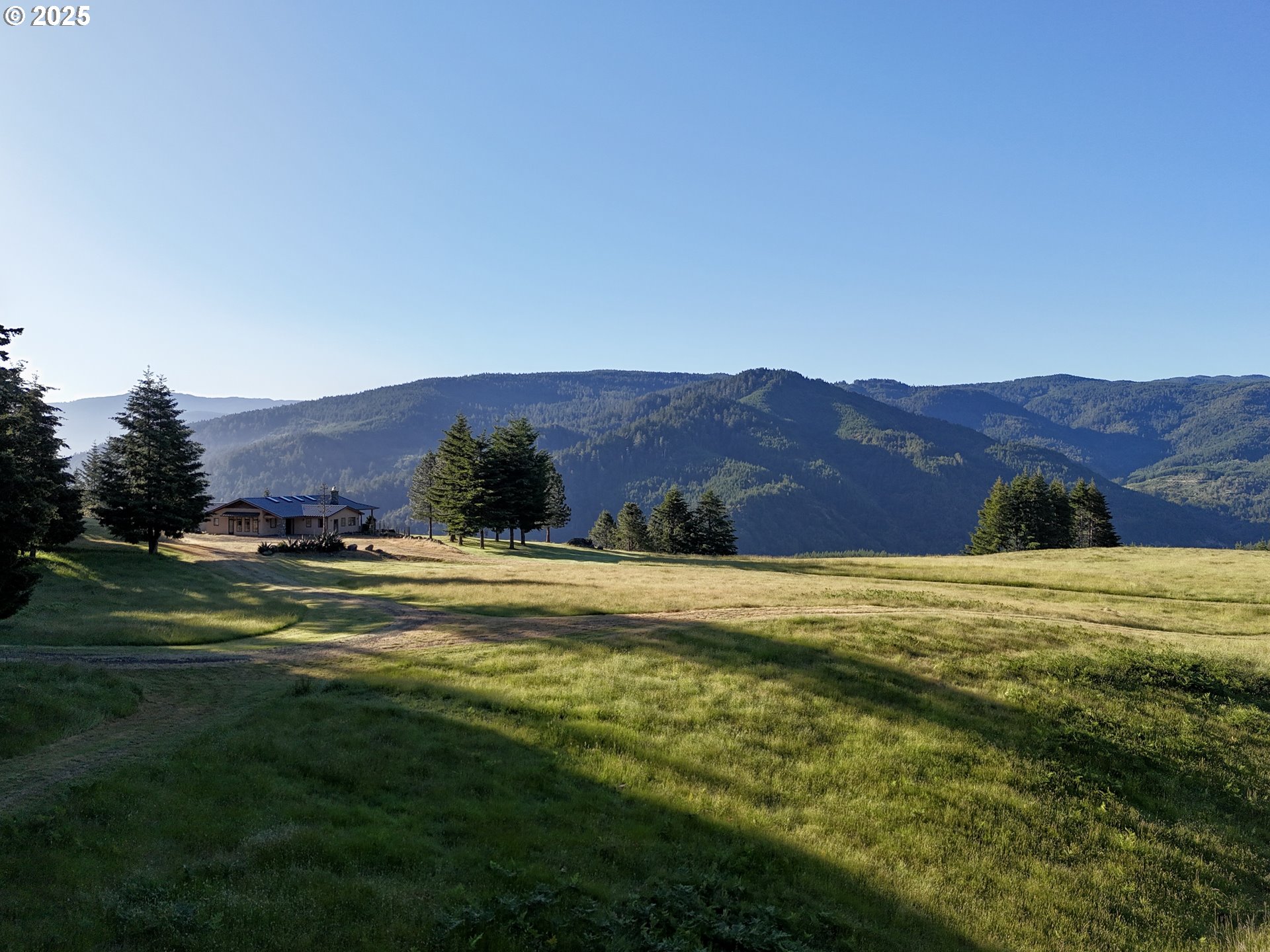 32855 Miller Ranch Road Gold Beach, OR 97444 - Photo 6 of 47 a view of a grassy field with mountains in the background