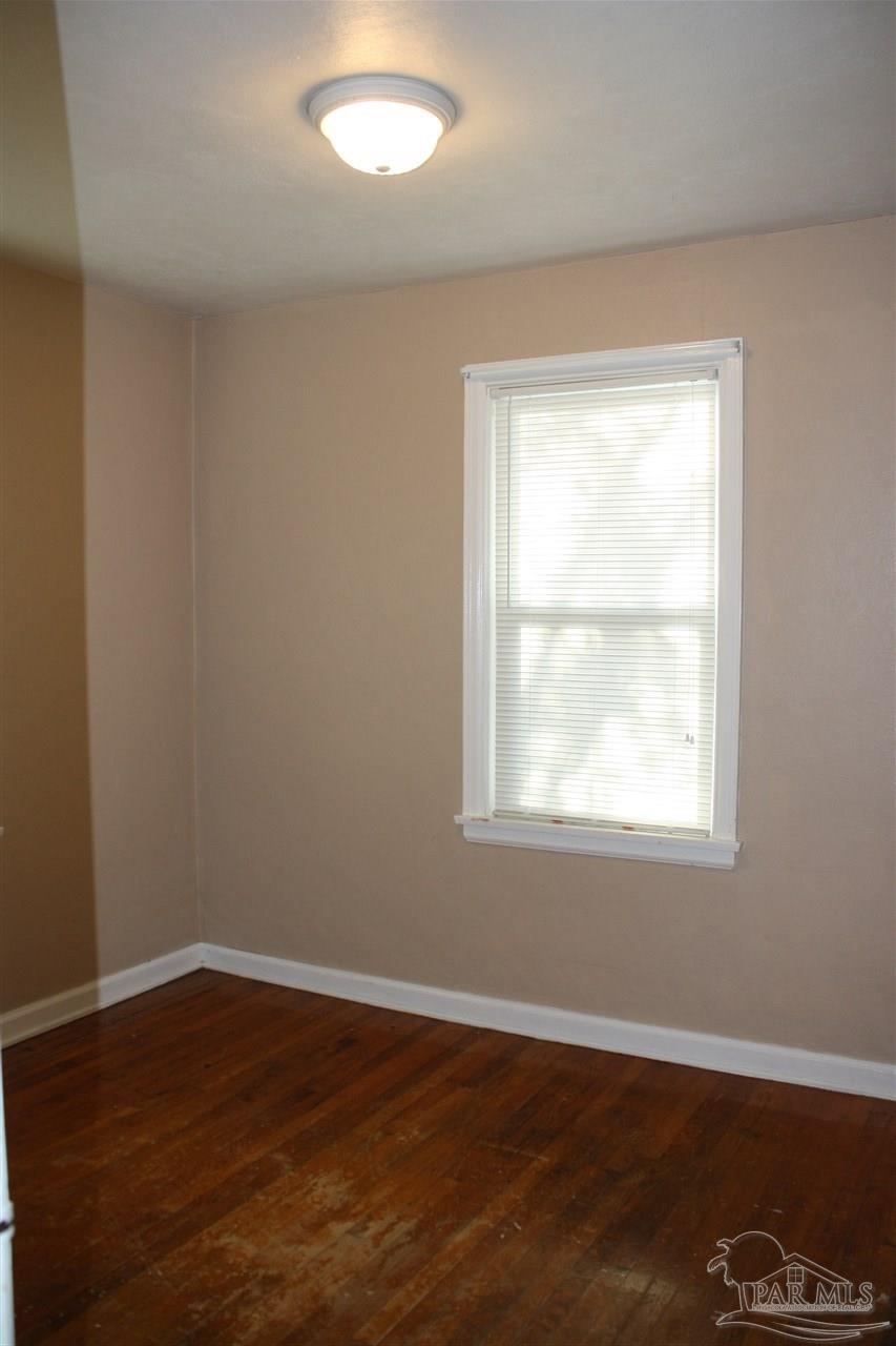 7195 Gillespie Road Milton, FL 32583 - Photo 12 of 14 an empty room with wooden floor and windows