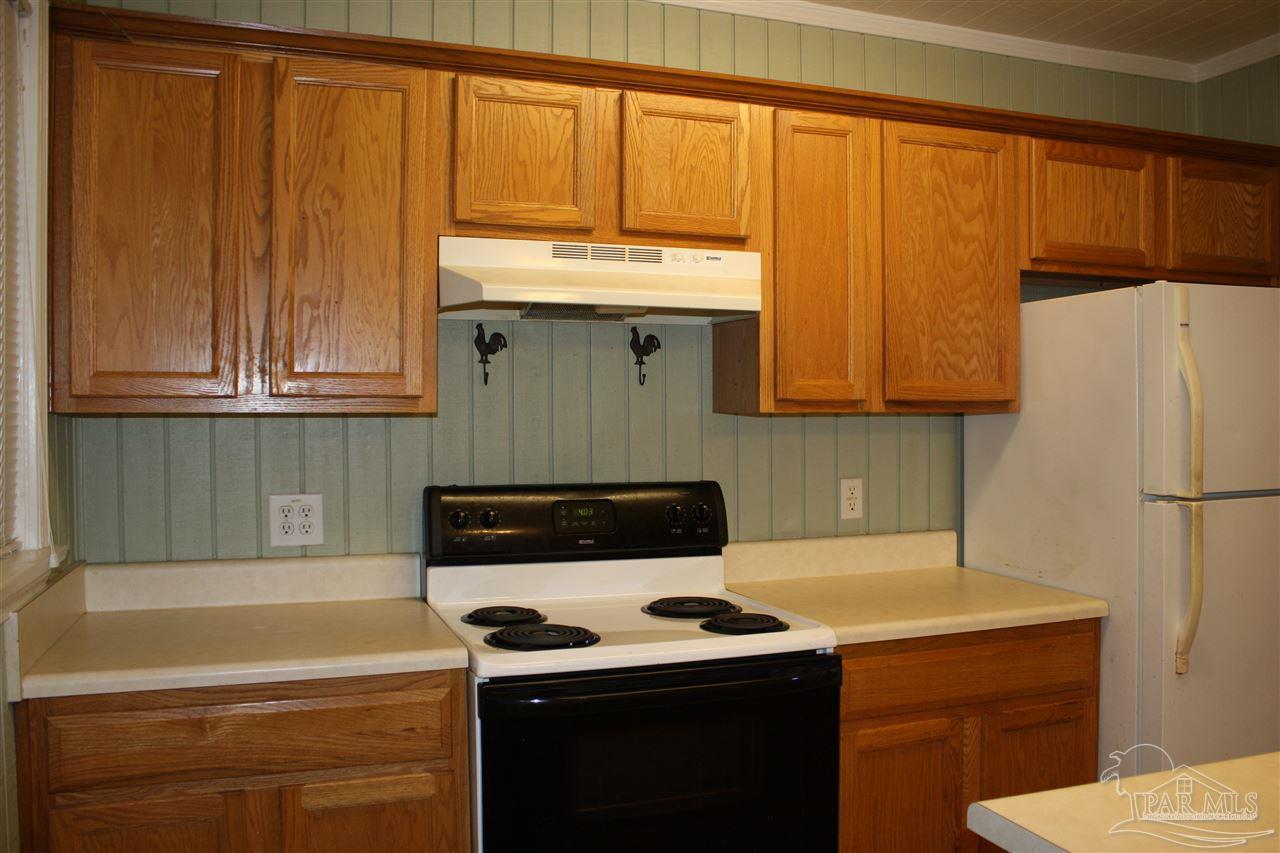7195 Gillespie Road Milton, FL 32583 - Photo 6 of 14 a kitchen with a sink a refrigerator and cabinets