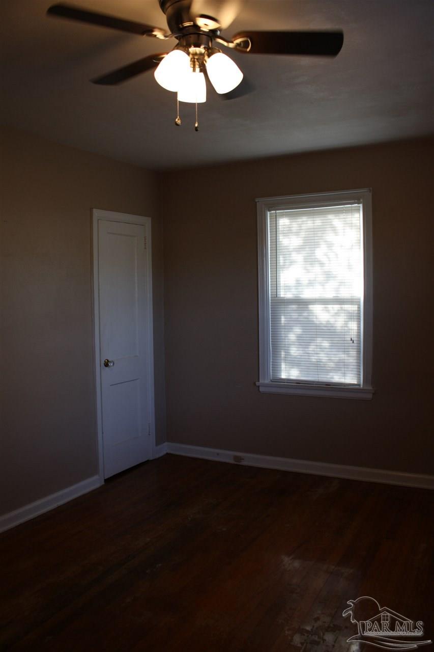 7195 Gillespie Road Milton, FL 32583 - Photo 10 of 14 a view of an empty room with wooden floor and a window