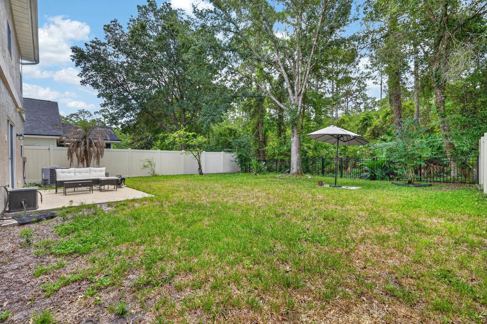 1237 Splendid Ravine Street St. Augustine, FL 32092 - Photo 33 of 62 a view of a backyard with a garden and trees