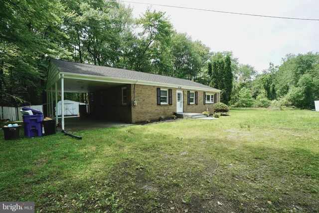 a view of a house with a backyard and sitting area