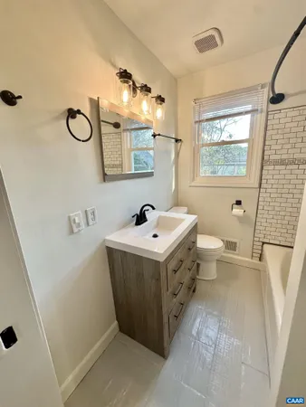 a bathroom with a sink and mirror with toilet