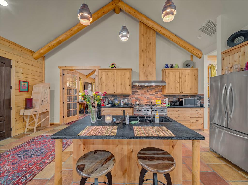 2197 Netherly Lane Forestburg, TX 76239 - Photo 16 of 40 a kitchen with stainless steel appliances granite countertop a stove a refrigerator a dining table and chairs with wooden floor