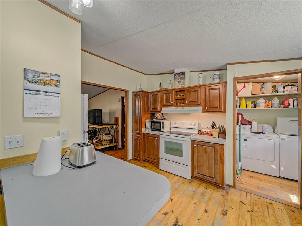 2197 Netherly Lane Forestburg, TX 76239 - Photo 31 of 40 a kitchen with cabinets and wooden floor