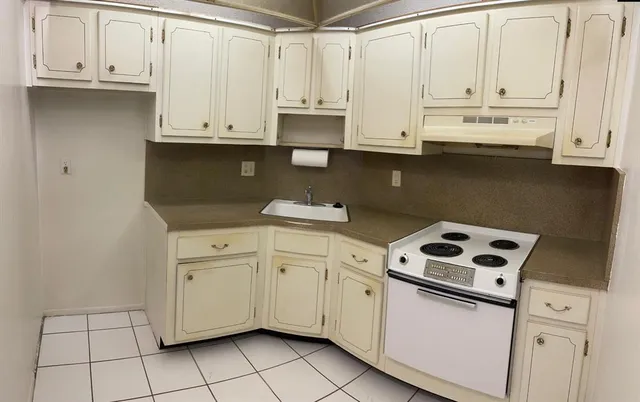 a kitchen with granite countertop white cabinets and sink