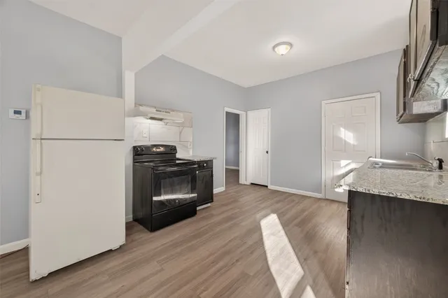 a kitchen with a sink stove top oven and cabinets