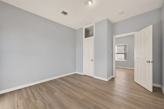 a view of an empty room with wooden floor