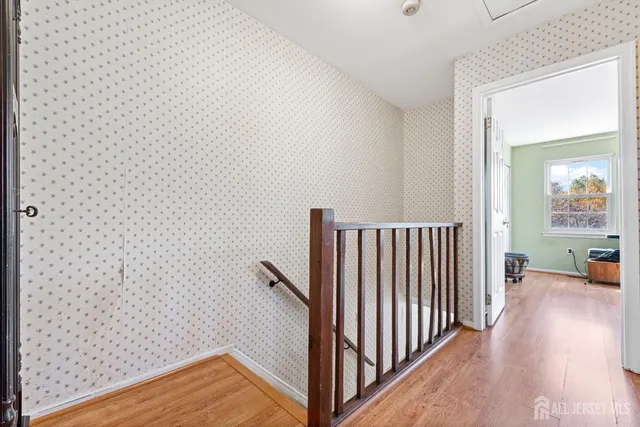a view of a hallway with wooden floor and furniture