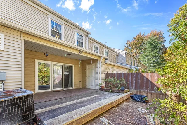 a view of a house with a small yard and wooden floor and fence