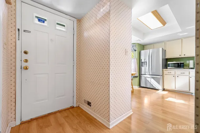 a view of a kitchen with a refrigerator a stove top oven and hallway