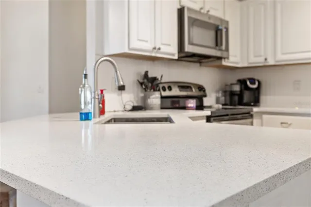 a kitchen with stainless steel appliances granite countertop a sink a stove and a microwave