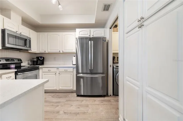 a kitchen with stainless steel appliances a refrigerator sink and microwave