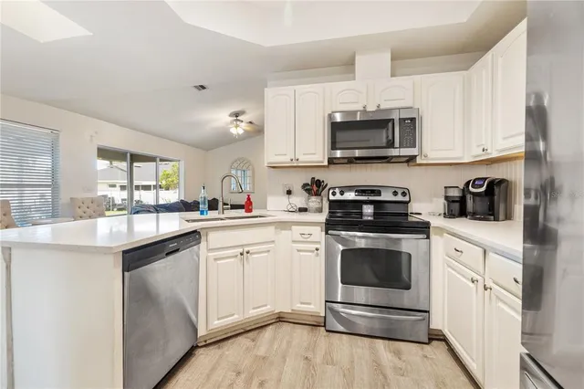 a kitchen with stainless steel appliances granite countertop a stove a sink and a microwave