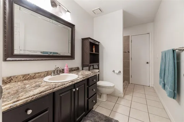 a bathroom with a double vanity sink toilet and mirror