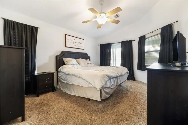 a bedroom with a bed dresser and a large mirror