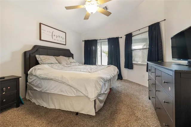 a spacious bedroom with a bed and a flat screen tv