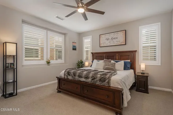 a bedroom with a bed lamp and a window
