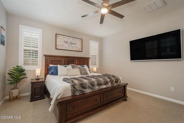 a spacious bedroom with a bed and a flat screen tv