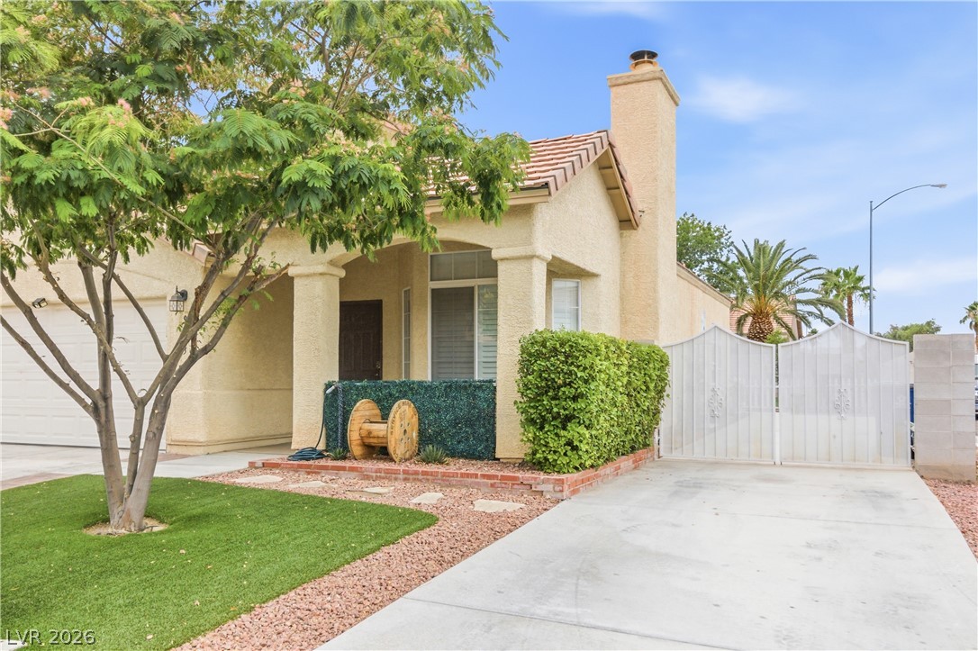 9523 Observer Street Las Vegas, NV 89123 - Photo 3 of 42 A well-kept front yard with mature trees and a neatly trimmed hedge welcomes you.