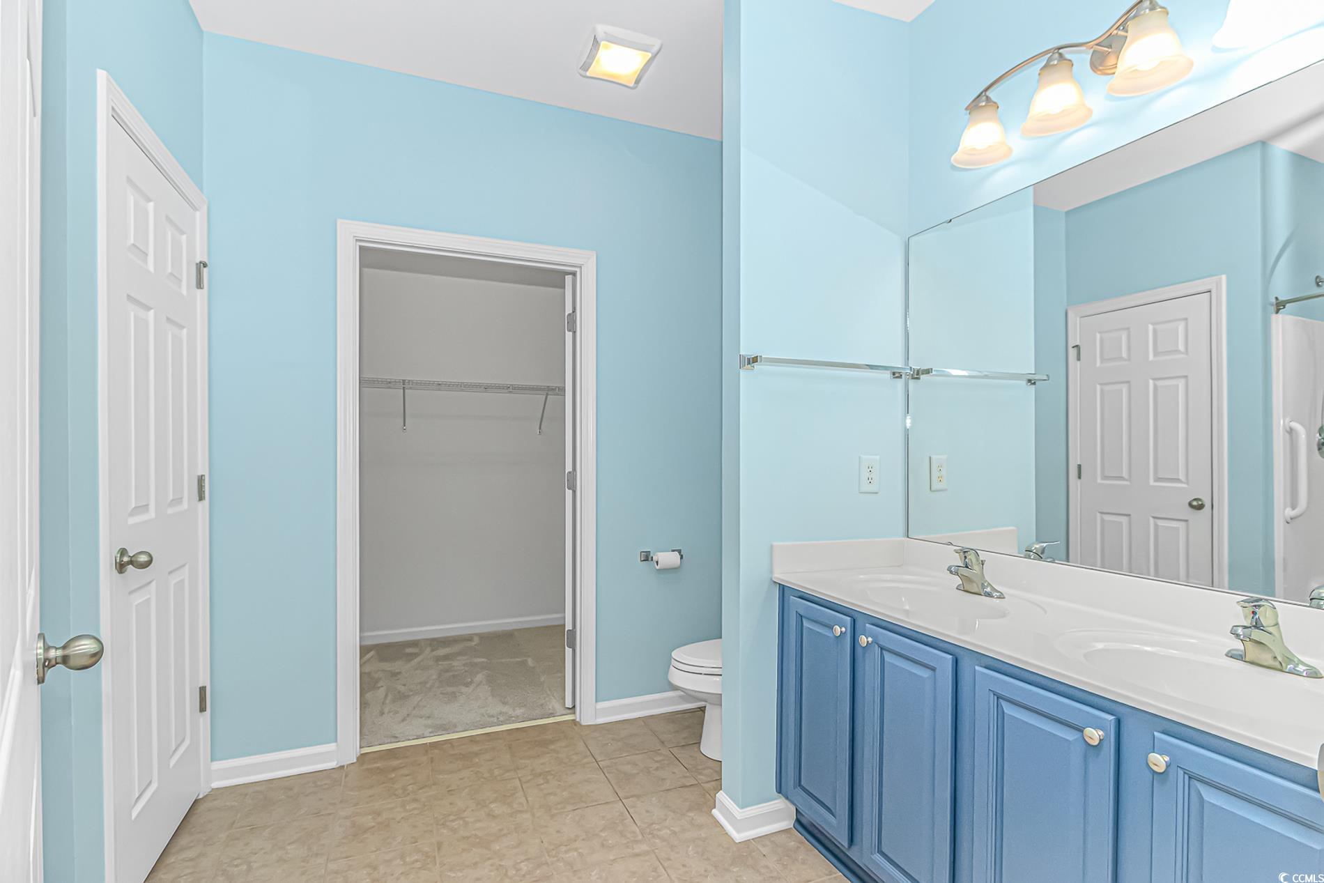 139 Chenoa Drive, Unit D Murrells Inlet, SC 29576 - Photo 15 of 34 Bathroom featuring double vanity, a walk in closet, and light tile patterned floors