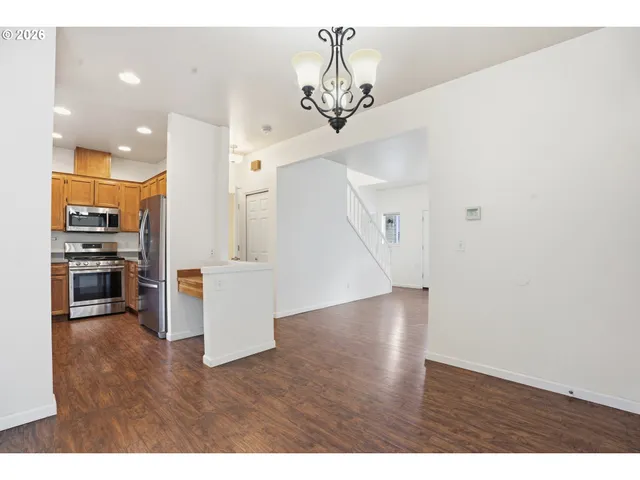 a view of a living room and kitchen with wooden floor