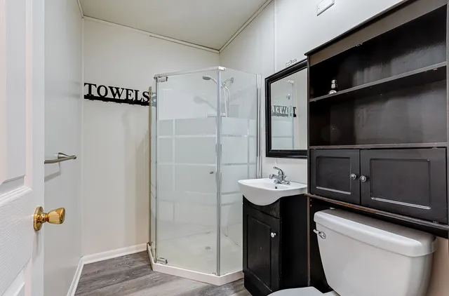 a bathroom with a sink a toilet and shower