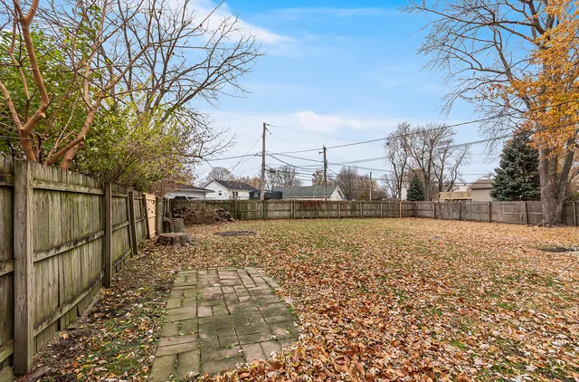 a view of a yard with wooden fence