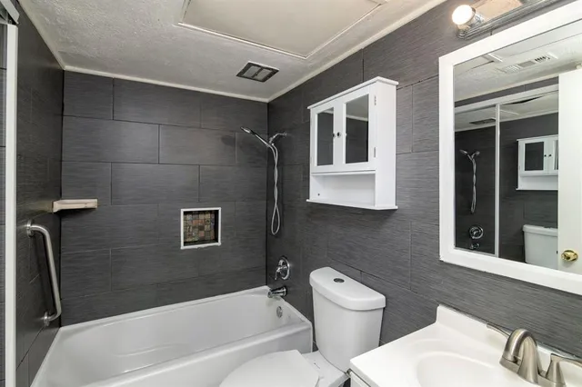 a bathroom with a granite countertop sink a mirror and shower