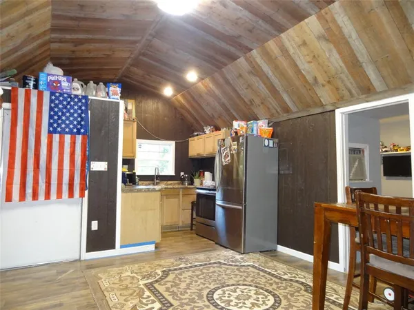 a kitchen with stainless steel appliances kitchen island granite countertop a refrigerator and a stove top oven