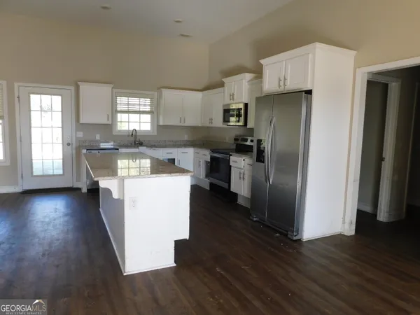 a kitchen with stainless steel appliances a refrigerator and wooden floor