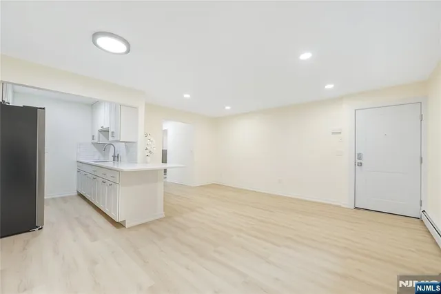 a view of kitchen with center island stainless steel appliances wooden floor and window
