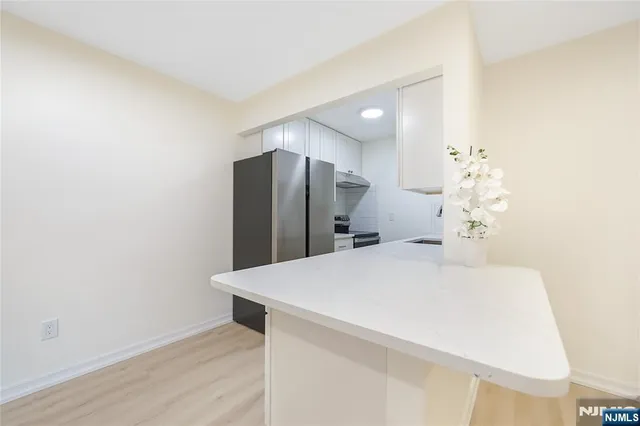 a close view of a refrigerator in kitchen and wooden floor