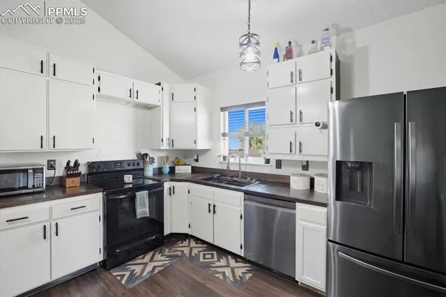 a kitchen with cabinets stainless steel appliances and a sink