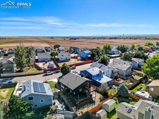 an aerial view of residential houses with outdoor space and parking