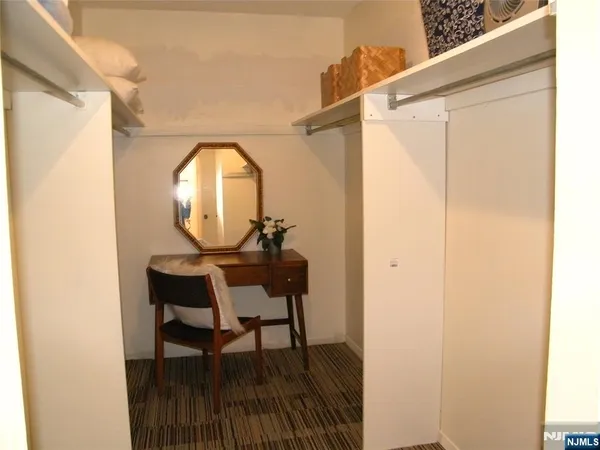 a view of a hallway with wooden floor and a dining table