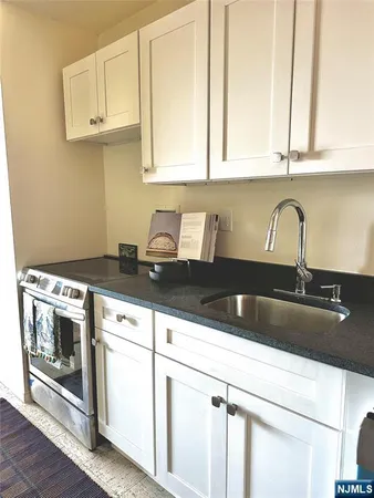 a kitchen with granite countertop a sink and cabinets