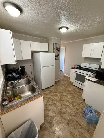 a kitchen with a refrigerator and a stove top oven