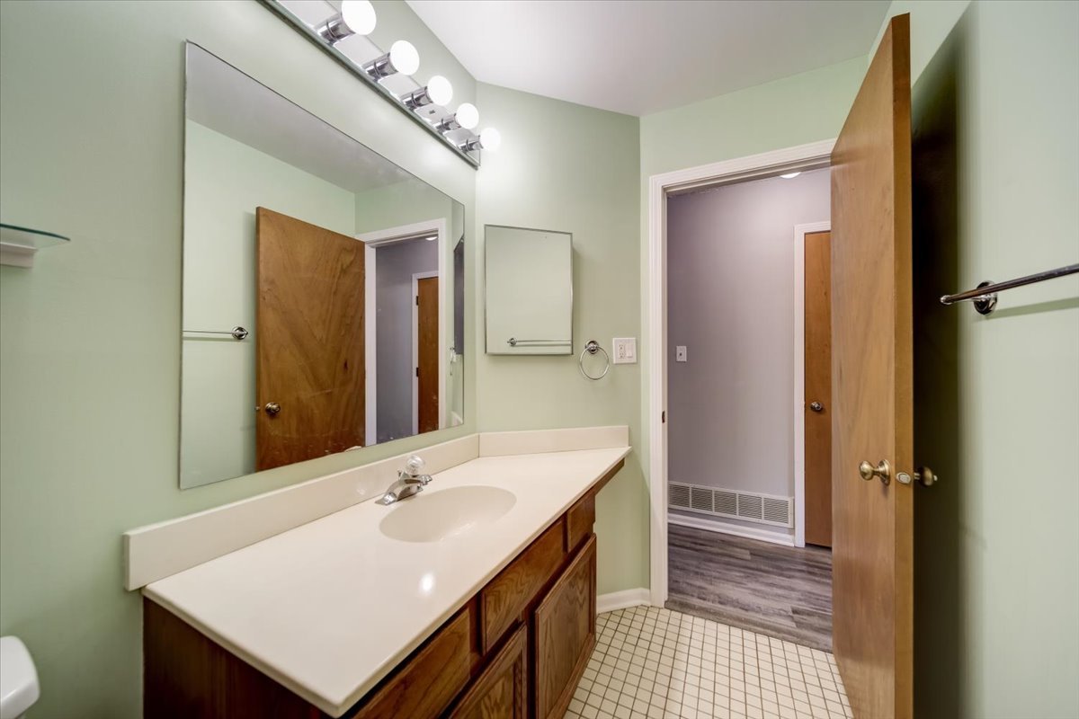 8325 High Point Circle, Unit A Darien, IL 60561 - Photo 21 of 42 a bathroom with a sink a mirror and a shower
