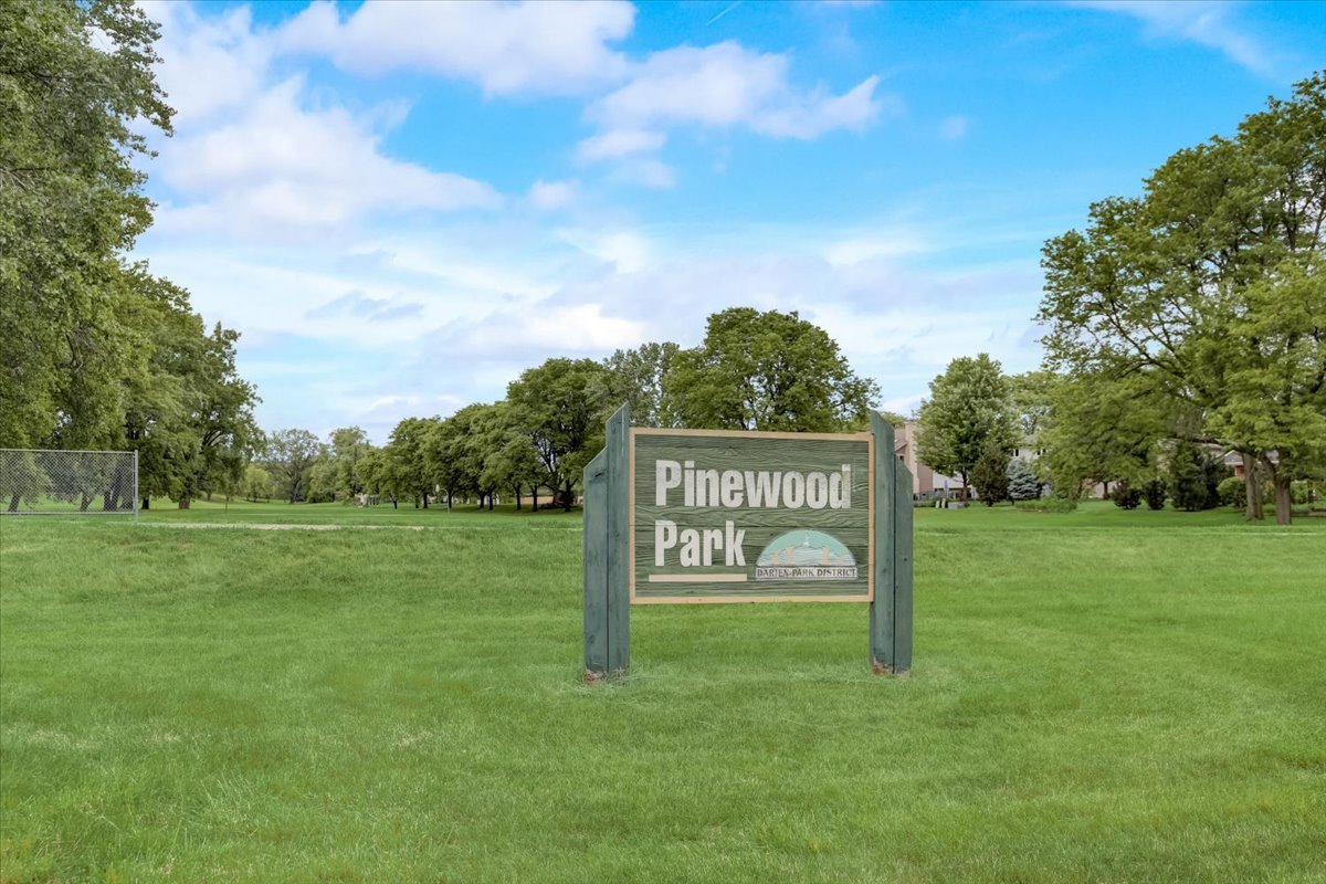 8325 High Point Circle, Unit A Darien, IL 60561 - Photo 33 of 42 a sign that is sitting in the grass near a tree