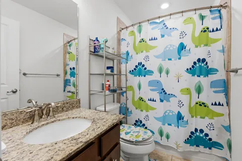 a bathroom with a granite countertop sink a vanity and a tub
