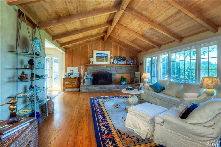17294 High Road Sonoma, CA 95476 - Photo 1 of 1 a living room with furniture a fireplace and a table