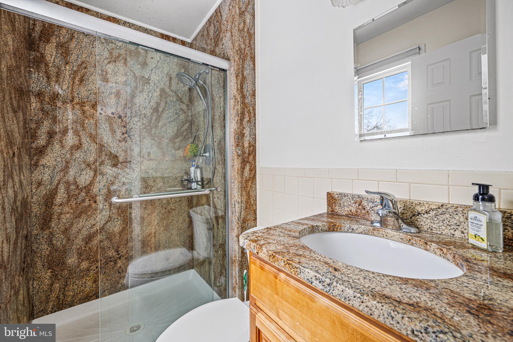 3205 Llewellyn Field Road Olney, MD 20832 - Photo 19 of 39 a bathroom with a granite countertop sink a mirror and a toilet