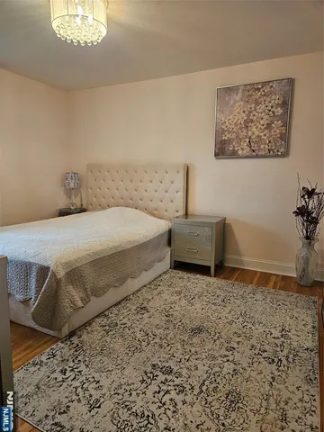 a spacious bedroom with a bed and a chandelier