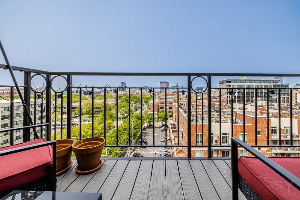 1250 West Van Buren Street, Unit 703 Chicago, IL 60607 - Photo 12 of 18 a view of a balcony with chairs and wooden floor