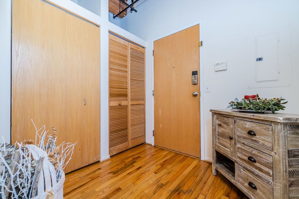 1250 West Van Buren Street, Unit 703 Chicago, IL 60607 - Photo 3 of 18 a view of a bedroom with wooden floor and cabinet
